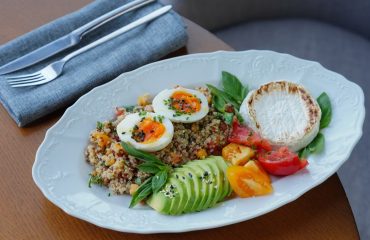 Delicious quinoa salad with sliced avocado, soft-boiled eggs, and fresh herbs.